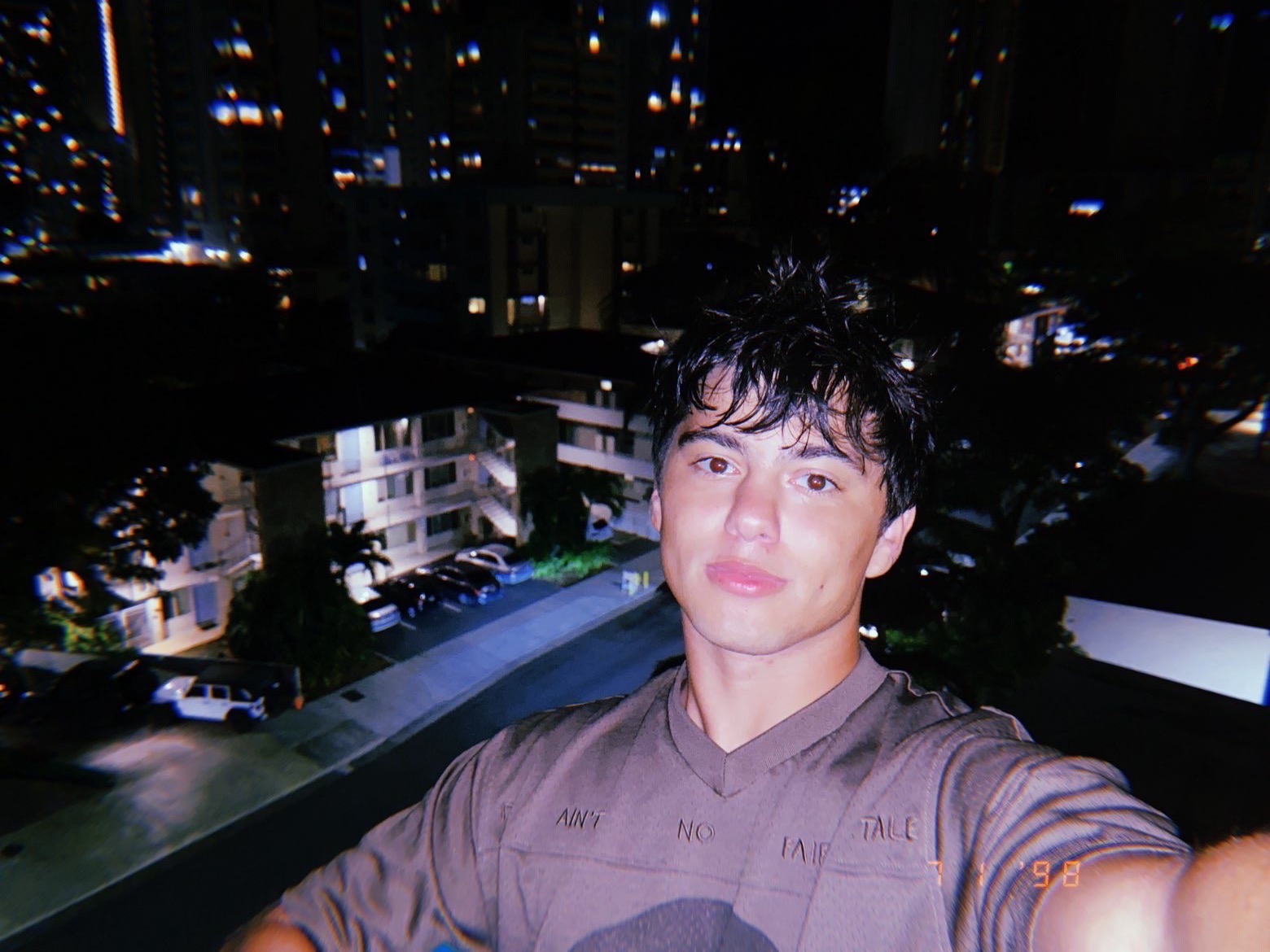 Tyler, founder of TSwebco, outdoors at night with city lights behind him